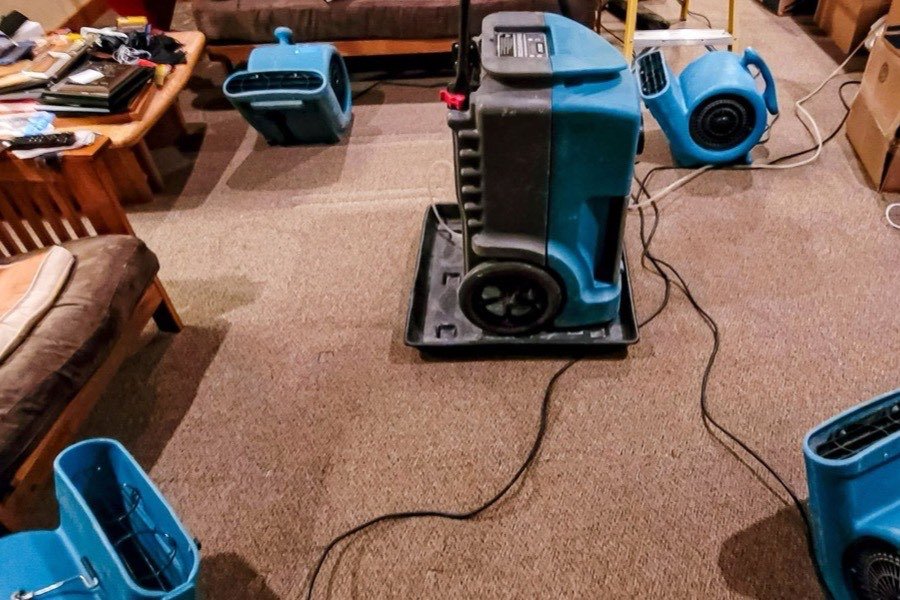 Extraction unit and air movers set up in a flooded living room