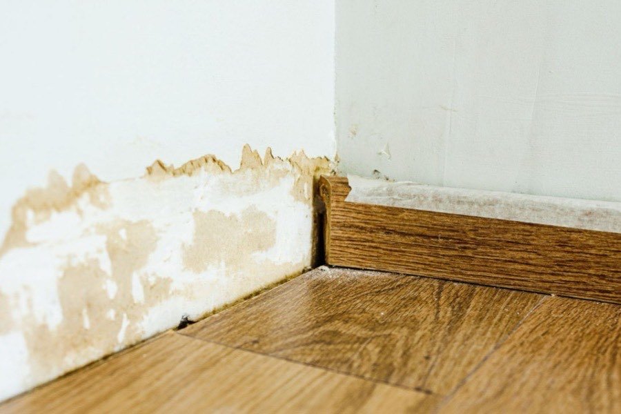 Water-damaged baseboard and wall ready to be rebuilt